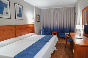 Port Denia في دينيا: غرفة في الفندق مع سرير ومكتب