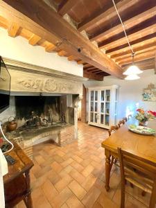 sala de estar con chimenea y mesa de madera en Intero Appartamento con Private Pool e Jacuzzi Podere Settefrati, en Montaione