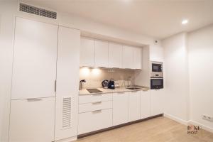 a white kitchen with white cabinets and appliances at Castilla Luxury 1C Apartment in Madrid