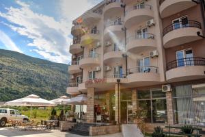 a large building with tables and chairs in front of it at Hotel Novi in Herceg-Novi