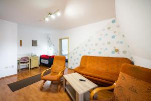 uma sala de estar com um sofá e duas cadeiras em Hotel Sugas em Sfântu Gheorghe