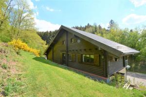 a log cabin in the middle of a grassy hill at Natur pur in der Vulkaneifel - Haus Hersbach in Mürlenbach
