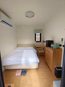 1 dormitorio con cama, escritorio y mesa en 鹿厝老街民宿, en Lukang
