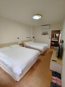 1 dormitorio con 2 camas y TV. en 鹿厝老街民宿, en Lukang