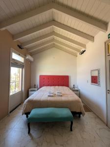 a bedroom with a large bed with a red headboard at Posada Villa Pituil in Barreal