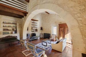 a living room with an archway with a couch and chairs at La Métairie près de Bordeaux in Haux