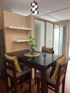 a dining room table with two chairs and a plant on it at 7 mins to SM Premiere & Port to Samal - Condo in Davao City