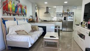 un sofá blanco en una cocina con un perro tirado en ella en Precioso dormitorio en el centro de Torremolinos, en Torremolinos