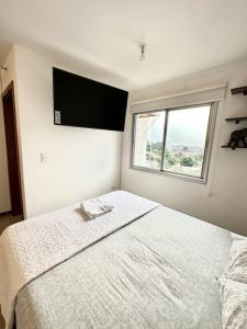 a bedroom with a large bed with a flat screen tv at Hermoso Loft Zona Shopping Sol 03 in Asunción