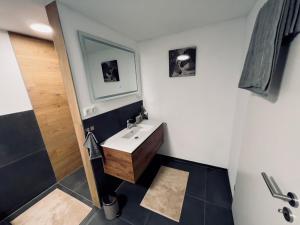 a bathroom with a sink and a mirror and a shower at Ferienwohnung Traum am Berg in Zwiesel