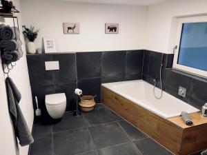 a bathroom with a bath tub and a toilet at Ferienwohnung Traum am Berg in Zwiesel
