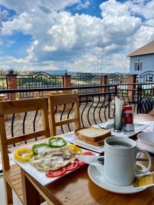 a table with a plate of food and a cup of coffee at Rwandeka in Kigali