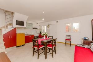 a kitchen and dining room with a table and red cabinets at House Ancica in Gornje Selo
