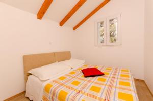 a bedroom with a bed with a red hat on it at House Ancica in Gornje Selo