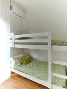 a white bunk bed with a green pillow on it at [RHO FIERA] Apartment near the Metro in Pero