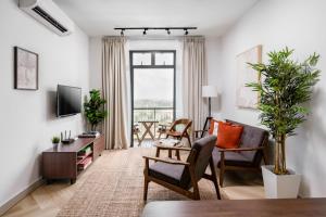 a living room with a couch and chairs and a tv at Casablanca Desaru in Desaru