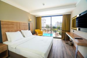 a hotel room with a bed and a large window at Ada Julian Marmaris in Marmaris