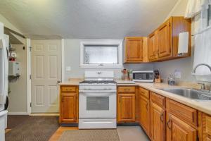 a kitchen with wooden cabinets and a white stove top oven at Quiet Plymouth Cottage on Great South Pond! in Plymouth +17 photos