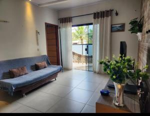 uma sala de estar com um sofá azul e uma televisão em Aconchego Premium em Angra dos Reis