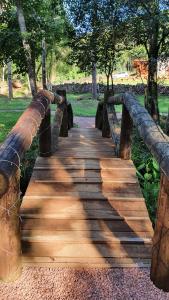 uma ponte de madeira num parque com árvores em L'esperienza - Pousada Butique - Ecoturismo em Nova Petrópolis
