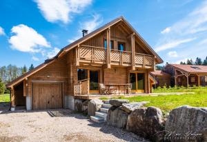 a log cabin with a garage in front of it at Chalet Charligustine - Gérardmer - 8p (4 étoiles) in Gérardmer