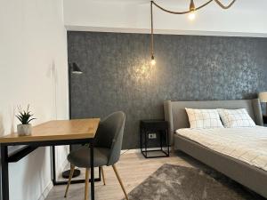 a bedroom with a bed and a table and a desk at City Center Accommodation - 308 in Reşiţa