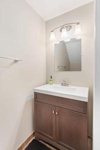 La salle de bains est pourvue d'un lavabo et d'un miroir. dans l'établissement Stylish and Cozy 1-BR Detroit, à Detroit
