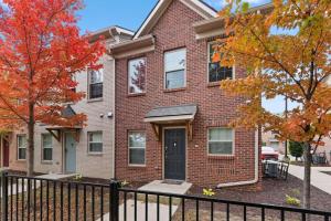 a brick house with a black fence in front of it at Stylish and Cozy 1-BR Detroit in Detroit