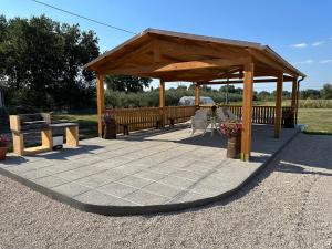 einen Pavillon mit einem Picknicktisch und einer Bank in der Unterkunft Casale Il Terranova in Cortona