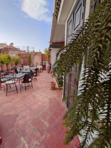 an outdoor patio with tables and chairs and plants at Riad Assalam in Marrakesh