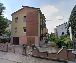 a brick building with a fence in front of it at Casa Mawi in Modena