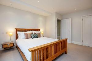 1 dormitorio con 1 cama grande con marco de madera en Veeve - Majestic Oasis, en Londres
