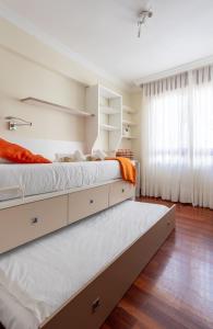 ベルメオにあるLAMERAGANE, en el centro histórico junto al parqueの白い壁と木の床の寝室にベッドが2つある