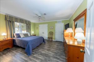 Un dormitorio con una cama azul y paredes verdes en Cosgrove's Cove, en Pine Knoll Shores