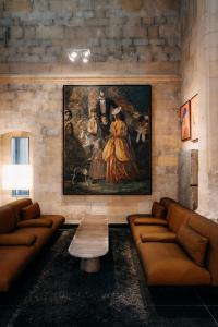 uma sala de estar com sofás e uma pintura na parede em Kruisherenhotel Maastricht - Oostwegel Collection, member of Design Hotels em Maastricht