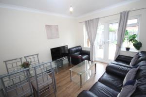 a living room with a couch and a table at Deane House in Ruislip