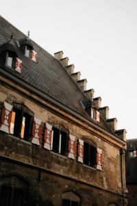 an old brick building with open windows on it at Kruisherenhotel Maastricht - Oostwegel Collection, member of Design Hotels in Maastricht