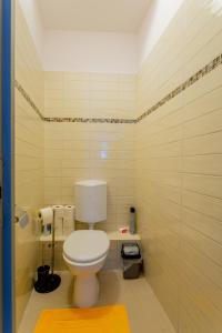 a bathroom with a white toilet and a yellow rug at Downtown Apartment House Orange in Budapest