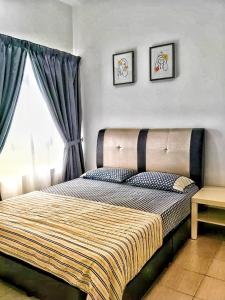 a bedroom with a bed with two pictures on the wall at Mesahill Nilai 2 Room Condo - Fast wifi, Parking & TV in Nilai