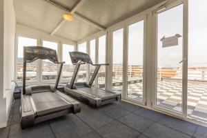 a gym with two exercise bikes in a room with windows at Downtown Apartment House Orange in Budapest