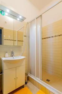 a bathroom with a sink and a shower at Downtown Apartment House Orange in Budapest