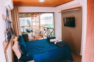 a room with a blue bed and a balcony at Chalé em condomínio beira mar in Barrinha