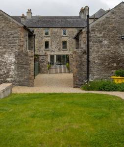 - une vue extérieure sur un bâtiment en pierre avec une cour dans l'établissement Stay Barrow Blueway - The Stables, à Monasterevin