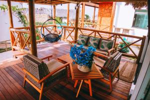 a patio with chairs and a table with a vase of flowers at Chalé em condomínio beira mar in Barrinha