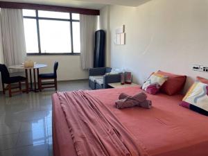 um quarto com uma cama grande e um cobertor vermelho em Flat no mar da baía de T. Santos em Salvador