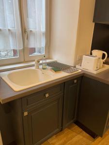 a kitchen with a sink and a counter top at la Montagnette les marmottes STUDIO maison en travaux de 10h a 17h in Moutiers