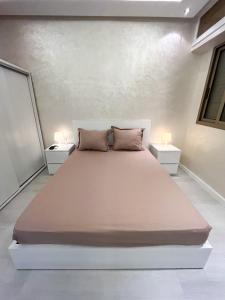 1 dormitorio con 1 cama grande y 2 mesitas de noche en L'Appartement Harmonia Cozy, en Casablanca