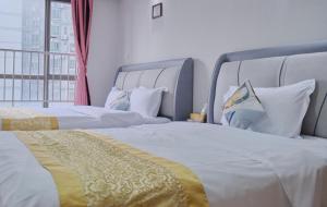 two beds in a hotel room with a window at Guangzhou Uhome Service Apartment in Guangzhou