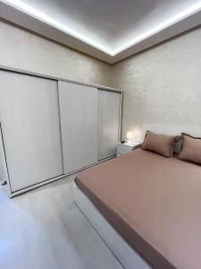 a bedroom with a bed and sliding glass doors at L'Appartement Harmonia Cozy in Casablanca