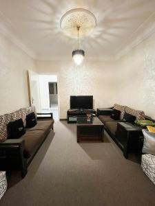 ein Wohnzimmer mit 2 Sofas und einem TV in der Unterkunft L'Appartement Harmonia Cozy in Casablanca